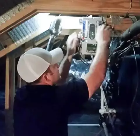 Prosper Air tech working on an HVAC unit in a customer's attic